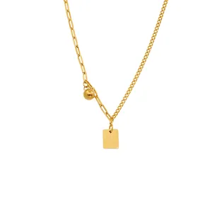 Dettaglio della collana in acciaio dorato con pendente Good Luck e maglie asimmetriche