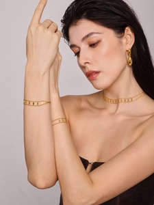 Close-up of geometric diamond charm choker and teardrop earrings on a model