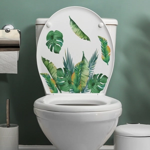 Detail of tropical green palm and monstera leaf decals on a white toilet lid