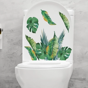 Detailed view of tropical palm leaves and monstera stickers on a white toilet lid