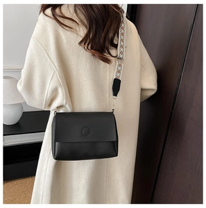 Black vegan leather tote with vintage patterned wide strap shown on model's shoulder