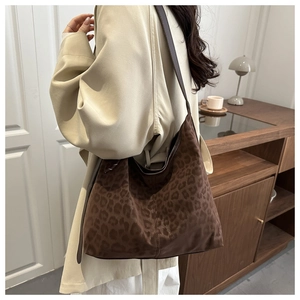 Close-up of leopard print tote bag featuring fuzzy texture and slim brown shoulder straps
