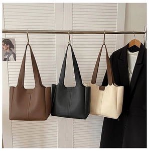 Detailed close-up showing brown, black, and beige tote bags with vertical stitching details