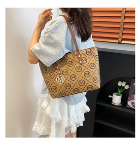 Vue détaillée latérale d'un grand sac cabas marron à carreaux avec pendentif M doré