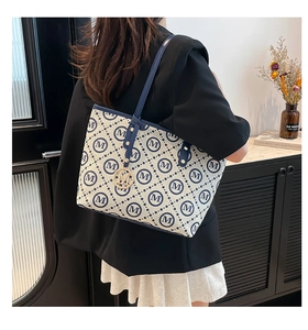 Détail du sac cabas à carreaux avec pendentif M doré et bandoulière en cuir sur modèle