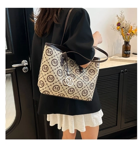 Détail du sac cabas monogramme avec lanières en cuir et pendentif M en métal argenté