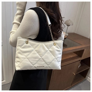 Gros plan sur le sac cabas blanc matelassé avec chaîne dorée et texture cuir gaufré