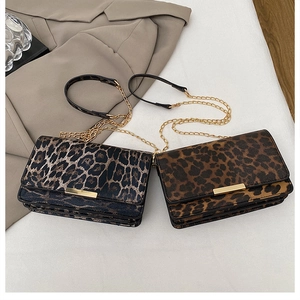 Detail view of leopard print crossbody bags in grey and brown with gold chain straps