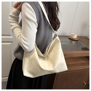 Macro detail of the creamy white wrinkled leather texture and wide shoulder strap