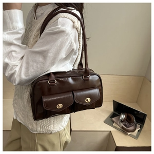 Detail der mokkabraunen PU-Leder Schultertasche mit goldenen Drehverschlüssen und Taschen