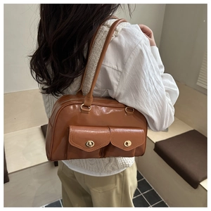 Nahaufnahme der karamellbraunen Retro-Boston-Tasche mit Metalldrehverschlüssen und Lederoptik