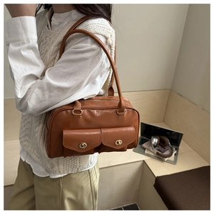 Detailaufnahme der braunen Vintage-Tasche aus Ölwachsleder mit zwei Taschen und Goldverschlüssen
