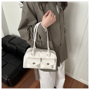 Nahaufnahme einer weißen Vintage Schultertasche aus Kunstleder mit goldenen Metalldrehverschlüssen