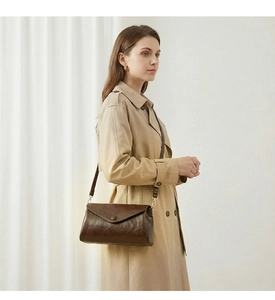 Deep brown vintage leather envelope crossbody bag featuring elegant gold hardware details