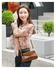 Detail of vintage brown leather crossbody bag paired with pink floral chiffon shirt