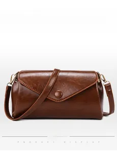 Detail of the brown vintage leather texture and gold-tone metal hardware on the handbag