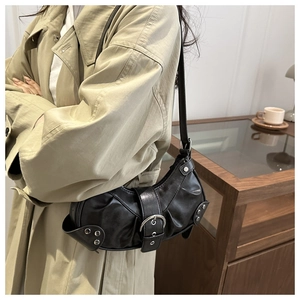 Chic black faux leather bucket bag with silver buckles and rivets shown on shoulder