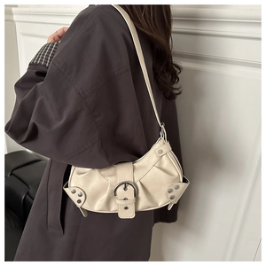 Detail of off-white crescent underarm bag with pleated faux leather and silver rivets