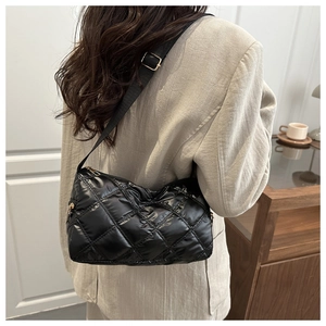 Close-up of black quilted nylon crossbody bag with gold zippers and adjustable strap