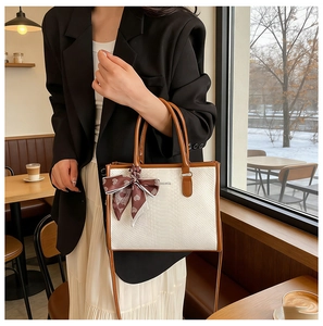 Schicke Handtasche aus weißem Leder mit Schlangeprägung und braunen Details im Café