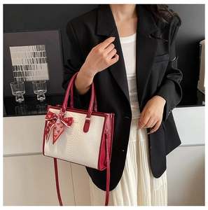 Detail der rot-weißen Handtasche im Color-Blocking-Design mit Schlangenmuster