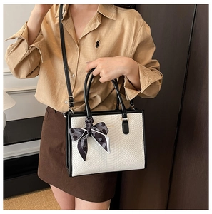Détail du sac cabas bicolore avec texture serpent et foulard décoratif à cœurs