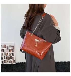 Brown crocodile embossed tote bag with gold deer charm and chain strap detail