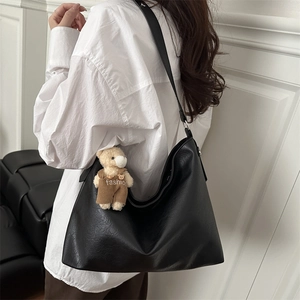 Black minimalist large capacity hobo bag with a cute brown bear charm on soft leather