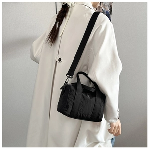 Detail of a black washed canvas small square bag with adjustable wide strap and matte buckles