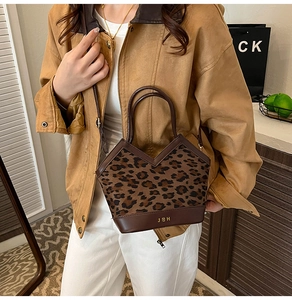 Detail of leopard print suede tote bag with V-shaped opening and dual leather handles