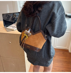 Detail of quilted brown shoulder bag with cute bear charm in a cozy lifestyle setting