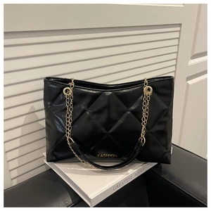Détail du sac cabas matelassé noir avec chaîne dorée et inscription élégante
