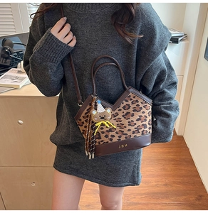 Detail of leopard print bucket bag with leather trim and decorative bear charm