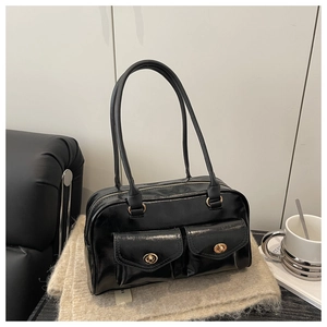 Détail du sac à bandoulière noir brillant avec deux poches à rabat et fermoirs dorés