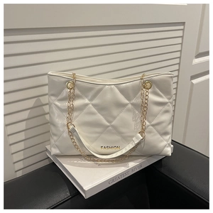 Détail du sac cabas matelassé blanc avec finition brillante et chaîne dorée