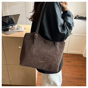 Detail of vintage matte leather tote bag with white contrast stitching and adjustable strap