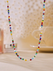 Close-up of colorful faceted crystal beads and oval pearls on a vibrant strand necklace