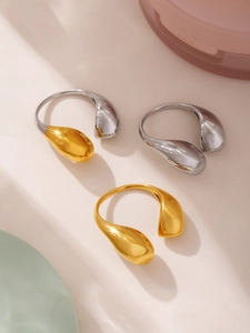 Detailed macro view of teardrop irregular geometric rings in gold and silver finishes
