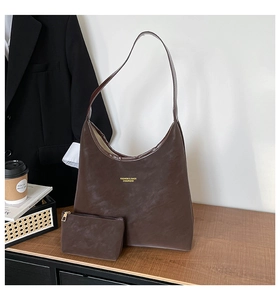 Detailed view of brown leather hobo bag and matching coin purse with gold text logo
