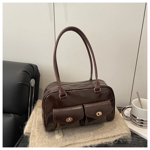 Détail du sac sous l'aisselle en cuir brillant marron avec fermoirs dorés rotatifs