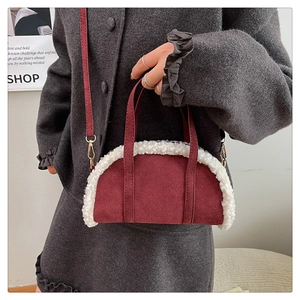 Détail du sac bowling en daim bordeaux avec bordure en peluche blanche et boucles dorées