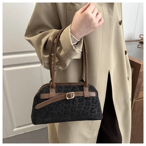 Detail of leopard print shoulder bag with brown leather straps and metal buckle decoration