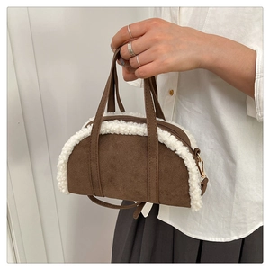 Détail d'un sac à main en daim marron avec bordure en peau lainée blanche et anses en cuir