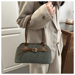 Close-up of olive green suede handbag with leopard pattern and gold hardware