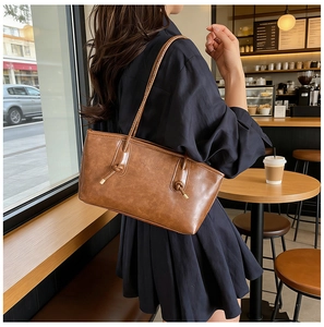 Close-up of a brown retro tote bag featuring stylish knot detail and rich leather texture