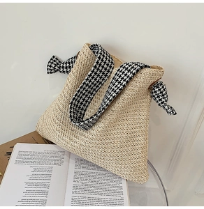 Detail of hand-woven straw bag featuring stylish houndstooth fabric wide shoulder strap