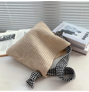 Detail of woven straw shoulder bag with stylish houndstooth strap and beige lining