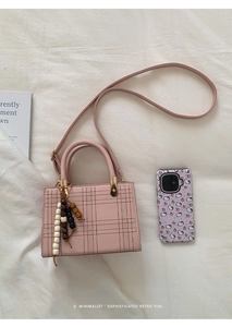 Détail du sac carré à carreaux roses avec breloque perles en bois et ferrures en métal