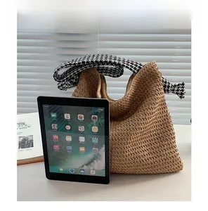 Straw shoulder bag size comparison with an iPad showing spacious interior and strap