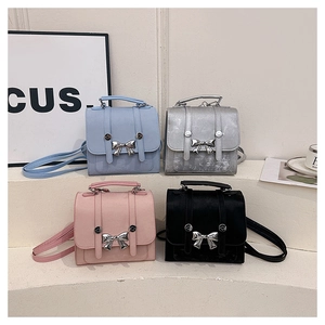 Detail of mini butterfly backpacks in light blue, silver, pink, and black on a white display